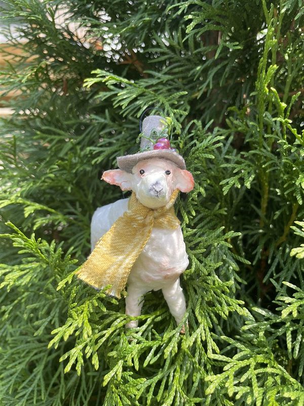 A vintage-style spun-cotton lamb ornament wearing a little hat and gold scarf